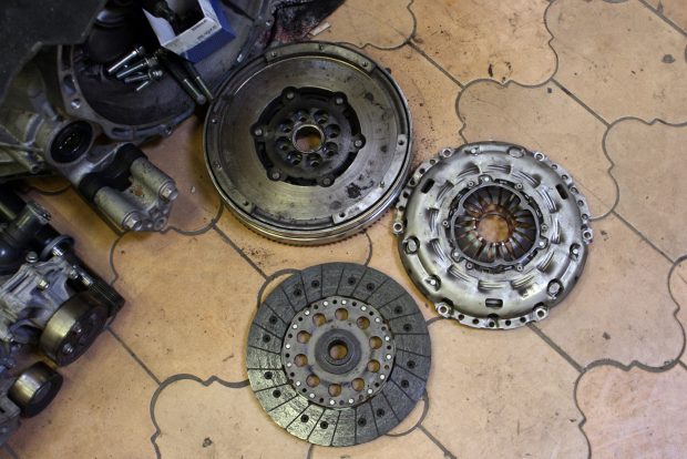 Mazda3: egy használt autó, amivel nehéz mellényúlni 5 Fent a kettős tömegű lendkrék, alul középen a kuplungtárcsa, jobbra a kuplungszerkezet. Egy dízel kuplungcseréje lendkerékkel együtt elvihet 350 000 forintot, az 1,6-os benzinesekre ez megvan 120 000 forintból márkaszervizben