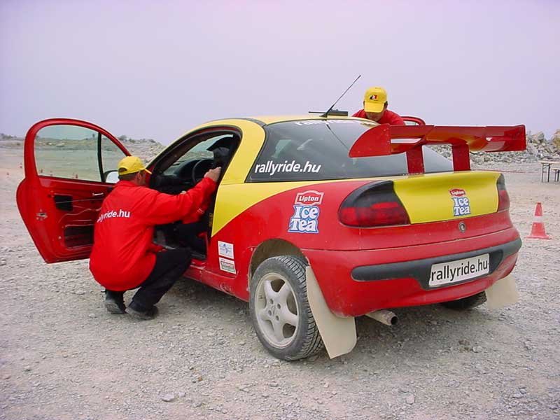 Az egyik segítő az öv bekötésénél segít, a másik a telemetria rendszert állítja be