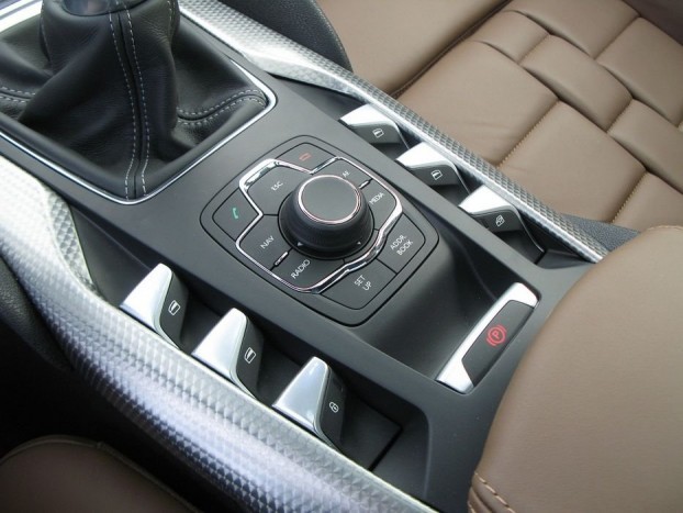 Széria az elektromos kézifék, előtte a központi vezérlőgomb. Használata némi márkaismeretet feltételez, például a navigáció térképének visszahozására (mondjuk a rádió átállítása után) nem egy itt megtalálható MAP (térkép) gomb szolgál, hanem egy teljesen máshol elhelyezett képernyőváltó gomb