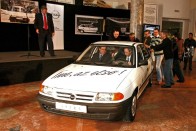 Kovács Tamás, az Opel Magyarország ügyvezető igazgatója vezet, mellette dr. Krámli Tamás, a Közlekedési Múzeum főigazgatója ül, a kollégák pedig tolják az autót