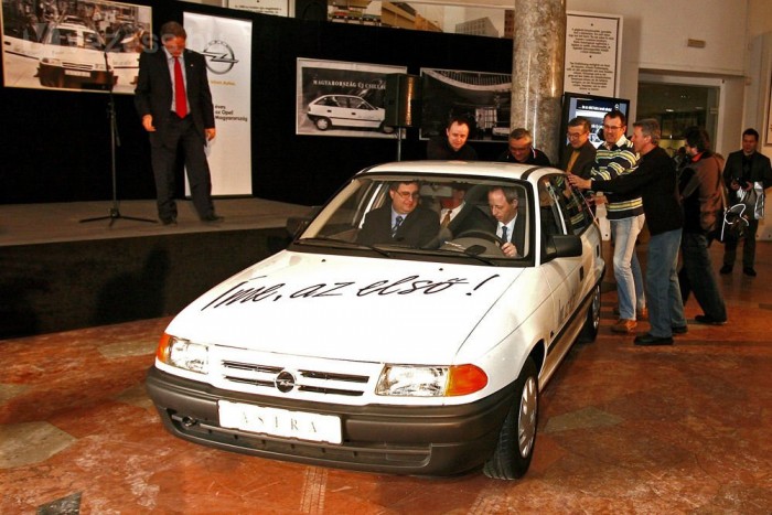 Kovács Tamás, az Opel Magyarország ügyvezető igazgatója vezet, mellette dr. Krámli Tamás, a Közlekedési Múzeum főigazgatója ül, a kollégák pedig tolják az autót