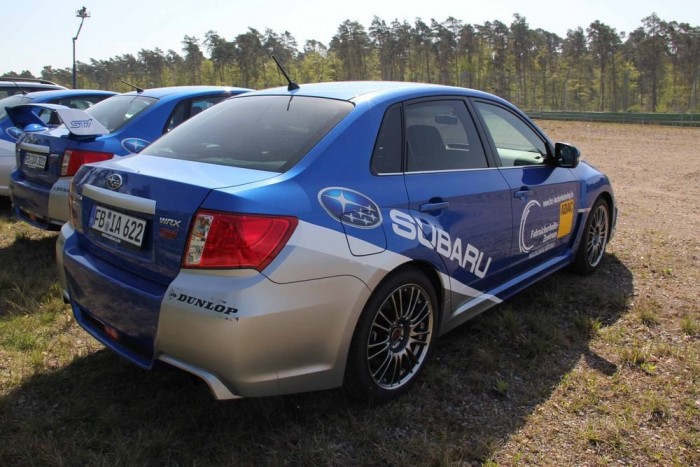 Egy autóverseny parkolója 6 | Vezess Messze a pálya külső részén állt egy nagy rakás Subaru WRX STi, négyajtós! kivitelben