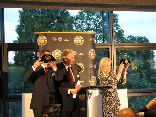 Karl-Friedrich Stracke, az Opel, és Susan Docherty, a Chevrolet első embere emeli magasra a trófeát. Közöttük Az év autója zsűri svéd elnöke, Hakan Matson