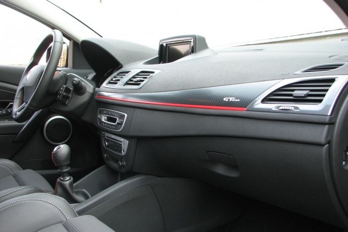 A műkarbon betét a piros csíkkal megosztja az emberiséget. Nekem csak ez tetszik az egész kabinban (meg a klímakonzol), egy renault-s tesztalanynak viszont csak ez nem