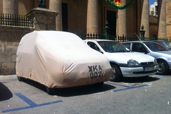Budapest belvárosában előfordul, hogy egyesek ponyvával próbálják megúszni a parkolási díjat, az ellenőrök ugyanis nem nyúlhatnak hozzá, nem hajthatják fel a rendszámnál. A jogszabály persze azt mondja, hogy a ponyvára ki kell írni az azonosítót, ahogy ezen a máltai kocsin látható.