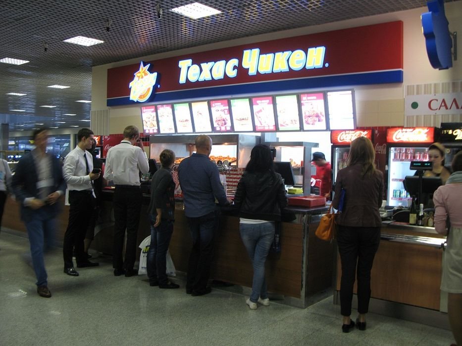 Ez egy büfé a sok közül. Angolul úgy írnák a feliratát, hogy Texas Chicken, vagyis texasi csirke. A cirill betűk használata miatt mindent fonetikusan írnak le