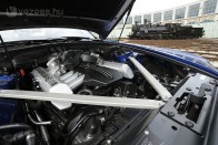A hatalmas, festetlen acél motorháztető alatt a BMW 12 hengeres benzinmotorjának RR-méretre, 6,75 literre fúrt blokkja lapul. Dehogy lapul, terpeszkedik