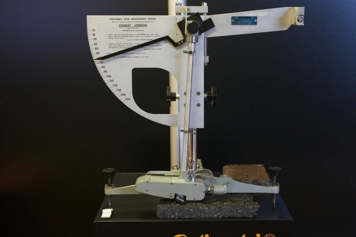 A régi útfelület-elemző, a Brit Inga. Az ember elengedi az ingát, a gumitalp megsúrolja az aszfaltot, a mutató valamennyire kimozdul. Aztán, ha felülről nézem, 40 az érték, ha alulról, 50. Ilyen mérések alapján címkézik a gumikat a gyártók