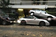 A békésen parkoló Porsche 997 kabrió mögött pont volt még annyi hely, hogy beférjen a Range Rover. Annak sofőrje annak rendje és módja szerint be is állt, de a manőver végén a fék helyett a gázra lépett, és mint egy biliárdgolyót, kilőtte a Porschét, egyenesen beékelve azt az előtte álló Opel alá. Személyi sérülés nem történt.