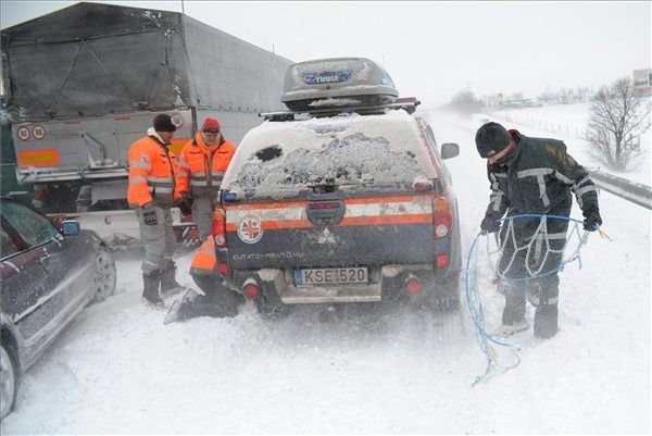 Hóláncot szerelnek a Pest Megyei Kutató-Mentő Szolgálat autójára az M7-es autópályán 2013. március 15-én. A mentőszolgálat dolgozói Fejér megyébe indultak, hogy elakadt mentőket mentsenek ki a hó fogságából.
MTI Fotó: Mihádák Zoltán