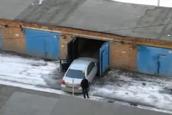 Női sofőr küzdelme a garázsajtóval