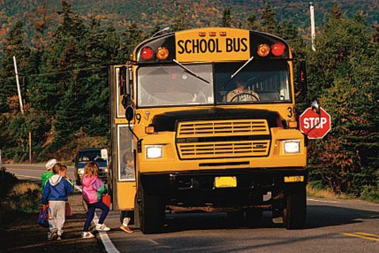Ezen a távoli tájon az iskolabusz oldalára szerelt Stop tábla figyelmezteti az autósokat