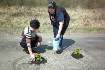 Muskátlikat ültet a kátyúkba a magyar polgármester