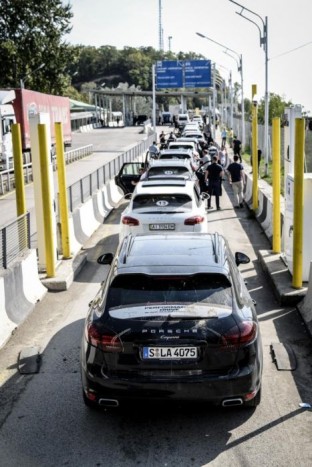 Luxusautóval Azerbajdzsánba 34 | Vezess A grúz-azeri határ egy olyan világot idéz, amit én már szerencsére nem éltem át. Gombóc a torokban, autók és utasaik külön kelnek át, hatalmas tányérsapkák árnyékában fürkésző tekintetek döntenek a sorsunkról. Pecsétekre, papírokra, apró kilépést biztosító cetlikre várunk órákon át, és fogalmam sincs, mire megy ki ez az egész.