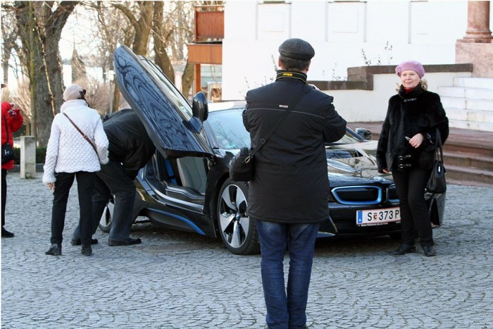Orosz turisták pózolnak az autó előtt, illetve dugdosnak bele telefont 