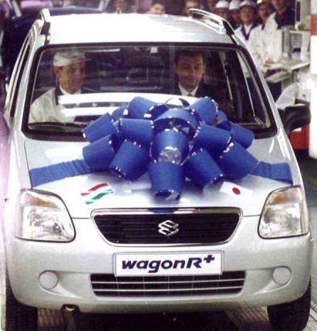 Az ezredfordulón nem jött világvége, sőt, Esztergomban megindult a Wagon R+ gyártása. Az ízléses masni majdnem eltakarja Európa akkori legfiatalabb miniszterelnökét, és Szoboszlai György minőségbiztosítási igazgatót