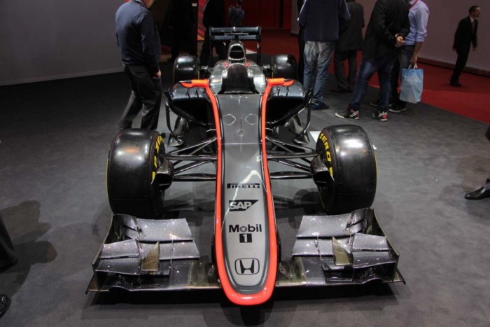 Igazi versenyautók a Genfi Autószalonon 12 McLaren MP4-30 - Az idei F1-es idény talán legnagyobb érdeklődést kiváltó autója, az újra feléledő McLaren-Honda kapcsolat első gyümölcse.
Az autón a legfeltűnőbb változás a tavalyival szemben, természetesen az új, hosszú orr, a McLaren a Lotusszal és a Willamsszel ellentétben a mélyen előrenyúló irányt választotta.
A szezon előtti teszteken eleinte megbízhatósági problémákkal küzdött, de az első futam előtt úgy tűnik sikerült megoldani a problémákat, és lehet pár jó villanása az ezüstszínű versenygépnek.