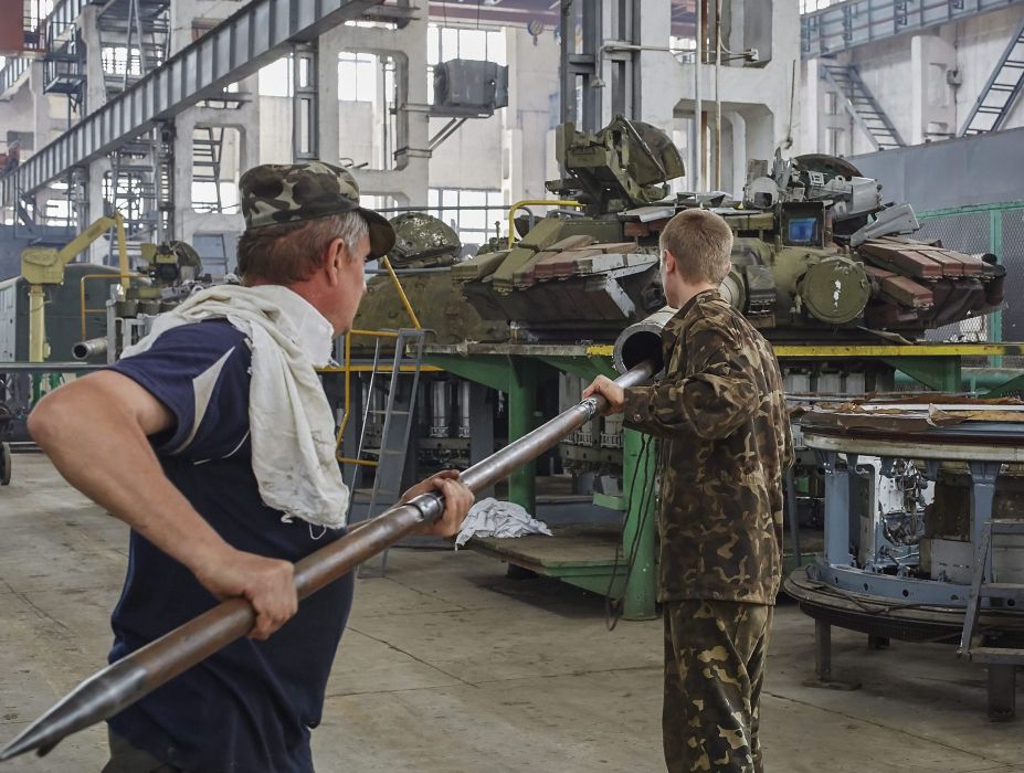 Munkások egy T-80-as harckocsi ágyúcsövét tisztítják a kelet-ukrajnai Harkiv egyik tankjavító műhelyében