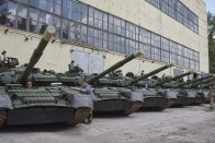 Munkások és az általuk felújított T-80-as harckocsik a kelet-ukrajnai Harkiv egyik tankjavító műhelyében