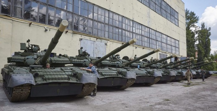 Munkások és az általuk felújított T-80-as harckocsik a kelet-ukrajnai Harkiv egyik tankjavító műhelyében