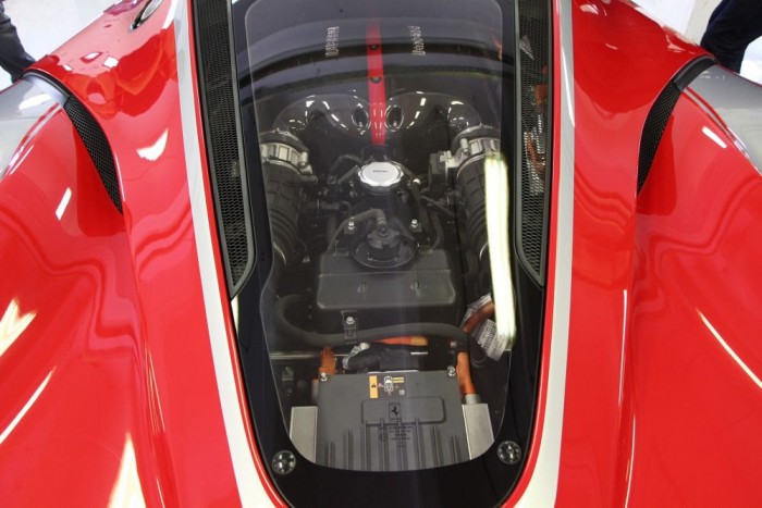 Üvegkupola alatt lakik a V12-es szörny, a narancsszínű vezetékek ere jelzi a lúdbőröztető előadás másodhegedűse a KERS rendszer jelenlétét.