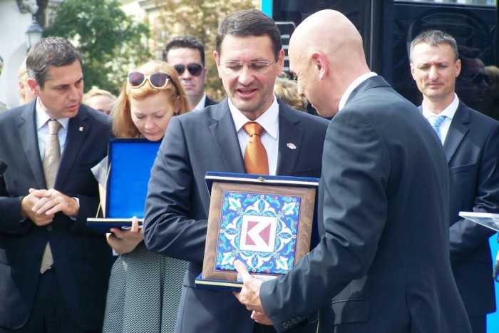 A török gyártó képviselője emlékplaketteket adott át a két busz átadása alkalmából. 