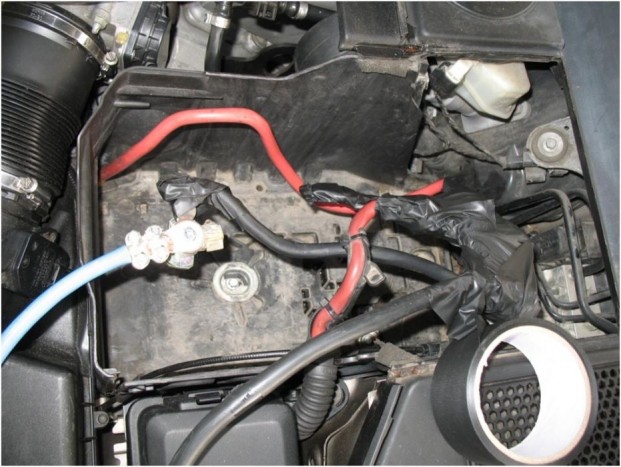 A kábel egyik végét rákötöttük az eredeti akku csatlakozó pontjaira a motortérben. Ehhez előre eltervezetten hoztunk csavarokat és alátéteket, hogy biztosítsuk az áram számára a megfelelő keresztmetszetet. A 4.4 literes motort ezen keresztül kell majd beindítani.