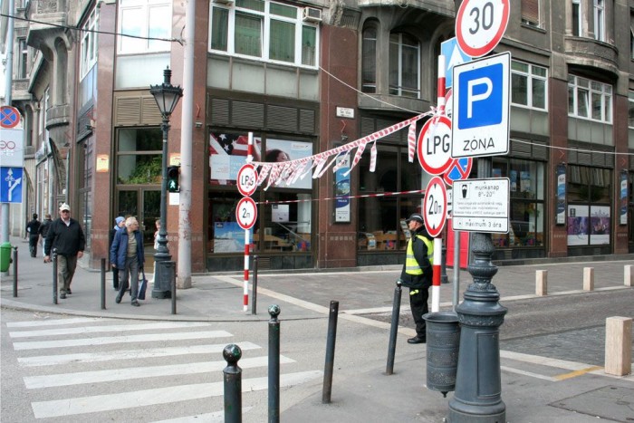 Kanyarodunk rá a Sas utcára, na, itt aztán van minden, akár a cirkuszban. Piros-fehér szalag vízszintesen kifeszítve 2 méter magasan, felette lógó szalagok, két oldalt KRESZ-táblák (gyanús lehet már itt az LPG-s tiltás), és még egy biztonsági őrt is kiállítottak. Két lehetőségünk volt” – mondja Tóth Sándor, a kivitelezést végző Budapest-Lipótváros Városfejlesztő Kft. vezetője -, vagy lezárjuk teljesen az utcát, vagy hosszabb ideig tart a felújítás ugyan, de szakaszos lesz a lezárás, viszont közben a mélygarázsba terelve az átmenő forgalmat, változatlanul használhatják az autósok az utcát. Minél kevesebb problémát és fennakadást akartunk okozni az autósoknak, és a vendéglátóhelyeknek, így utóbbi mellett döntöttünk