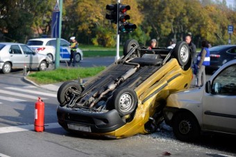 Gyalogos szorult egy felborult autó alá Bp.-en - fotók