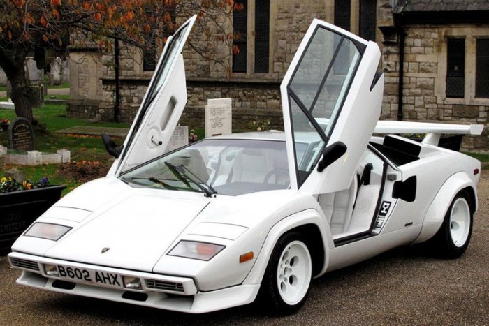 10. Lamborghini Countach
A fiúgyermekek első sportkocsi-álma, amely a maga korában nem csak nagybetűs poszterautóként hódított; talán kevesen tudják, de neve a piedmontese-i nyelvjárásban a szép nőt megbámuló vérbő férfit jelenti. Fickósság és feltűnőség – éppen a két legjellemzőbb tulajdonsága az 1974-től gyártott ragadozónak. Bertone kegyetlenül erőteljes kasztnijába V12-es blokkot szereltek változattól függően 400 vagy 500 lóerővel. Másfél évtizeden át gyártották, mégis csak bő 2000 darab készült belőle. Értékes műtárgy ma szerencsés kevesek fűtött garázsában.