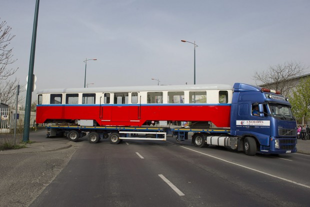 Budapest, 2016. április 6. A hûvösvölgyi gyermekvasút felújított BAW sorozatú személykocsiját szállító speciális jármû kanyarodik ki a MÁV fõvárosi XIV. kerületi Dózsa György úti javítómûhelyébõl 2016. április 6-án. A 66 éves, 10 tonnás, 16 méter hosszú kocsit, amelyet a Ganz Gépgyárban 1950-ben készítettek, daruval emelik a szintén felújított forgózsámolyokra a gyermekvasút hûvösvölgyi végállomásán. MTI Fotó: Lakatos Péter