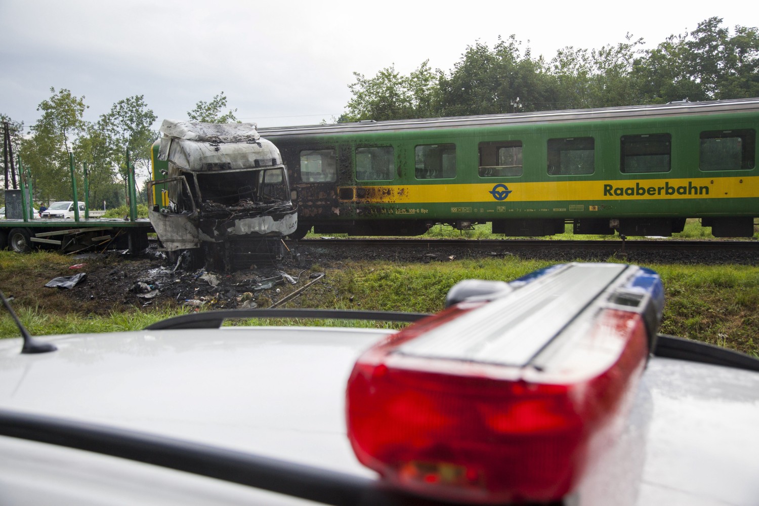 Barcs, 2016. július 25. Összeroncsolódott, kiégett kamion egy személyvonat mellett egy barcsi vasúti átjárónál 2016. július 25-én, miután a két jármû összeütközött. A kamion az ütközés következtében kigyulladt, vezetõje a helyszínen meghalt. A Sopron és Pécs között közlekedõ szerelvény mozdonyvezetõje és egy utasa könnyû sérülést szenvedett. MTI Fotó: Varga György