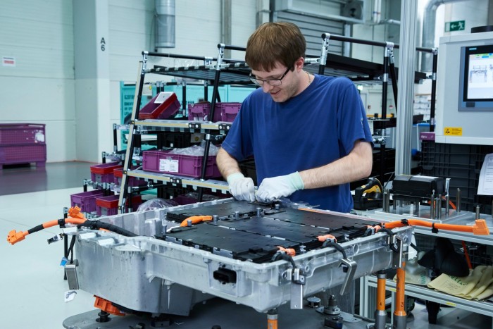 Boldog német munkás sorolja a koreai cellákat a BMW-nél