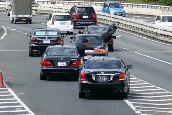 Ahogy a japán diplomatakonvoj pályára hajt, azt látni kell