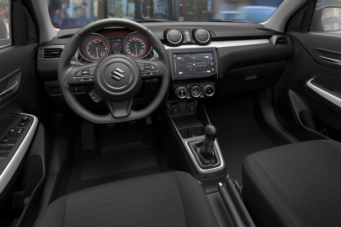 Itt az új Suzuki Swift! 3 A vezetőt felé forduló középkonzol, alul vágott kormánykerék, módosított formájú, határozottabb tömésű ülések várják.