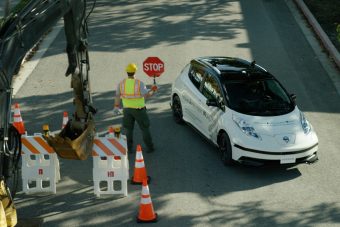 A sofőr segít a robotnak autót vezetni