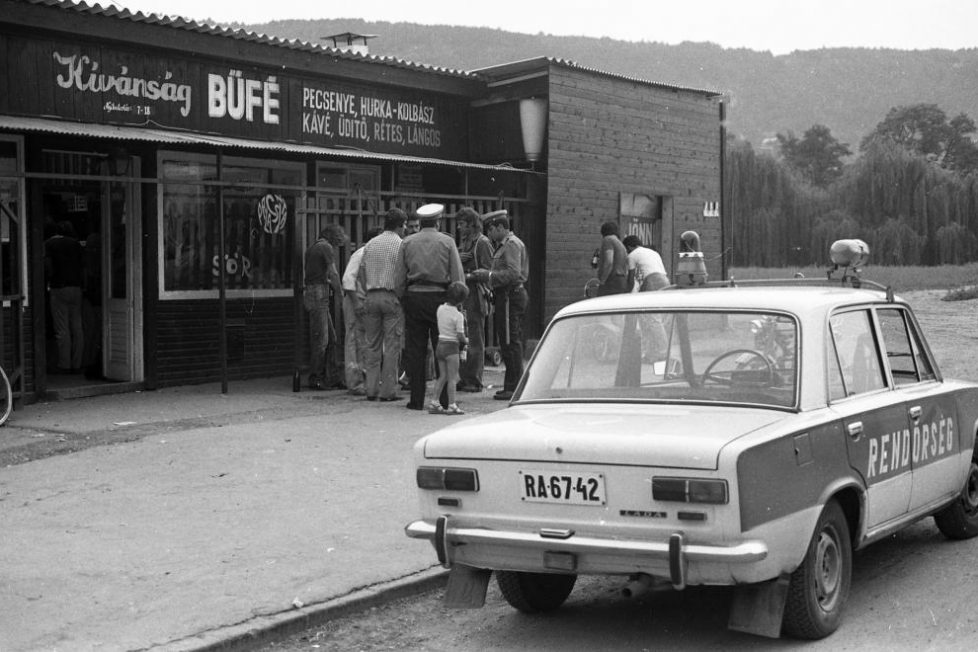 Egy letűnt kor rendőrautói – amikor még az 1600-os Lada volt a csúcs 10 A Hollós Korvin Lajos utca a Nád utcánál. Háttérben a Róka-hegy. A Ladán jól látszik a Villtesz villogó 1984-ig ilyeneket használtak a rendőrségnél. A lámpa különlegessége, hogy az égőt és a tükröt egy Wartburg ablaktörlő-motorja hajtja. Ennek megfelelően csörgött-zörgött az autó tetején, ráadásul ha kiszívta a nap a búra színét, nem sok fénye maradt. (FORTEPAN/MAGYAR RENDŐR)