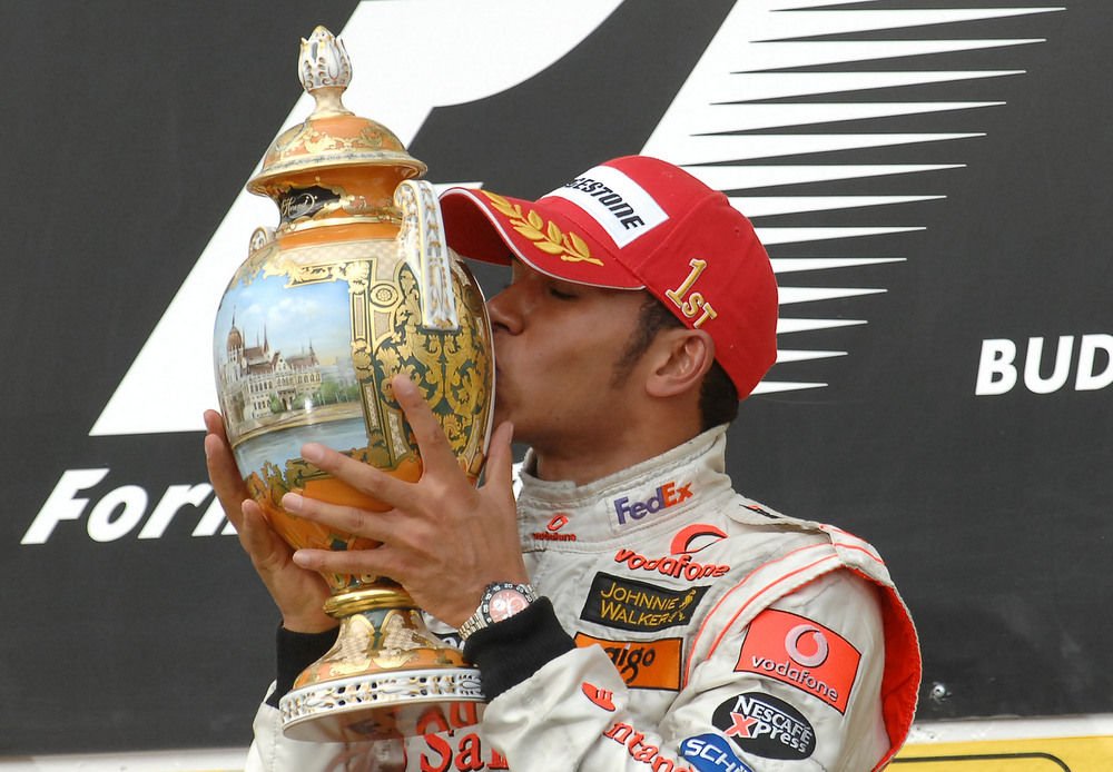 2007 - Lewis Hamilton a Parlament helyett az 'első helyezett' feliratot csókolja herendi trófeáján