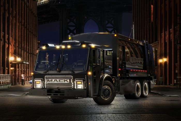 Kutya csücsül az új elektromos kukásautó orrán