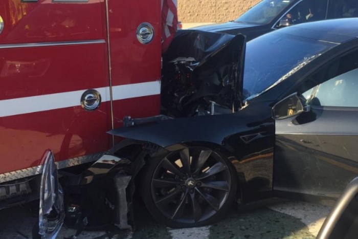 Tűzoltónak rohant a teslás, aki reggelizett az autóban