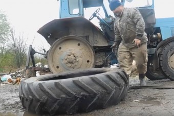 Gépek nélkül, puszta kézzel cserél kereket az MTZ-n az orosz melós