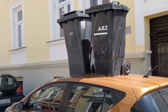 Tetőre tett kukákkal üzentek Pécsen egy kapuba parkoló autósnak