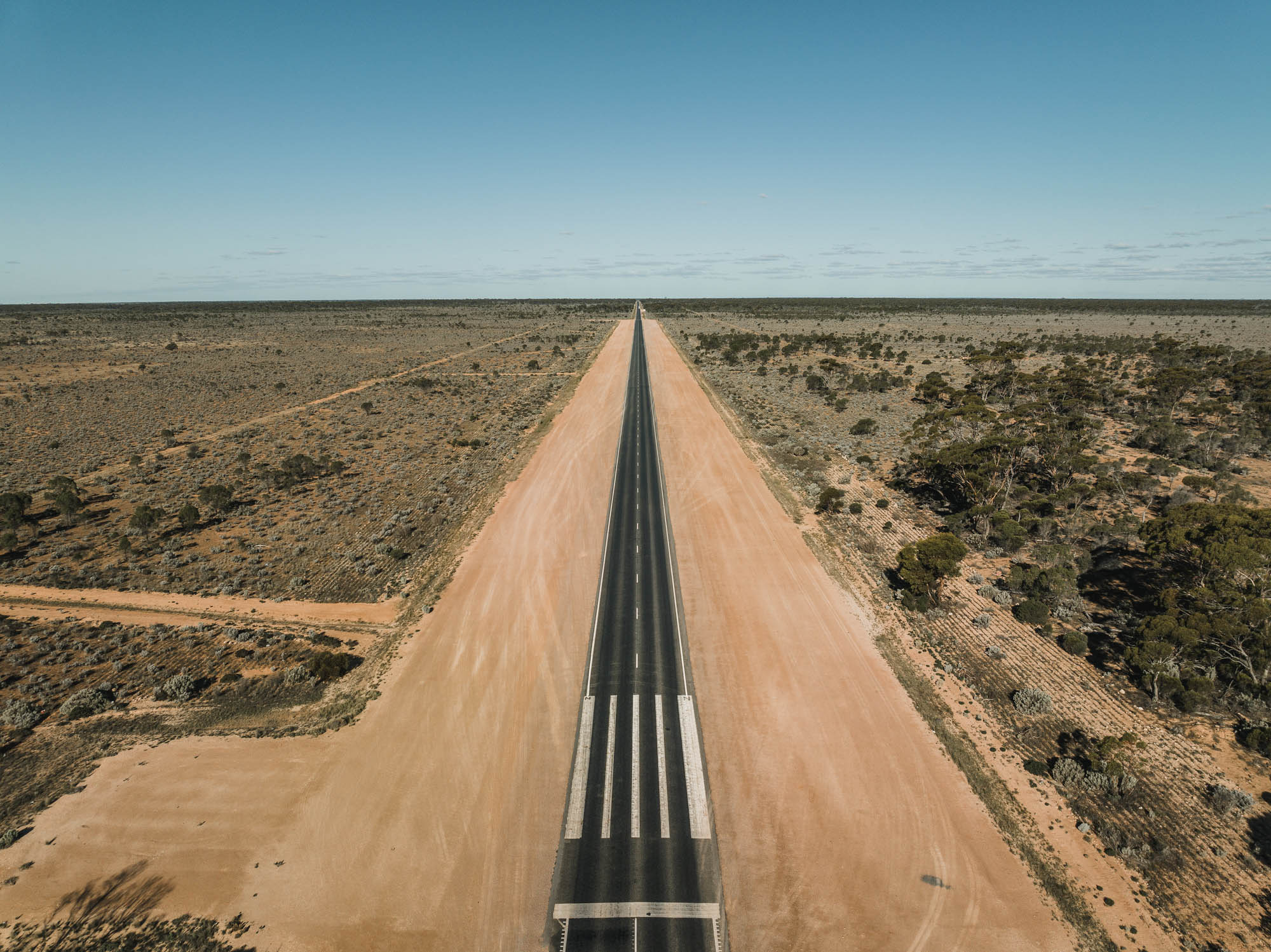 Aerial photo showing the Eyre Highway doubling up as a remote landing strip for the Royal Flying Doctor Service Western Australia Australia | Vezess | Vezess