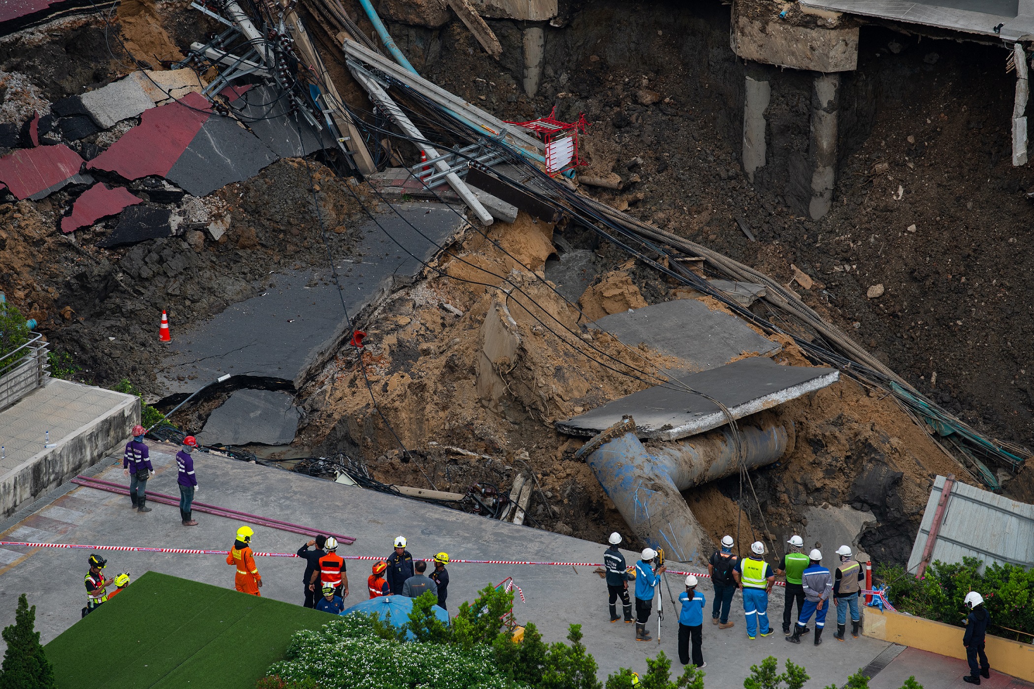 Rescue workers seen inspect a site of sinkhole next to the | Vezess | Vezess