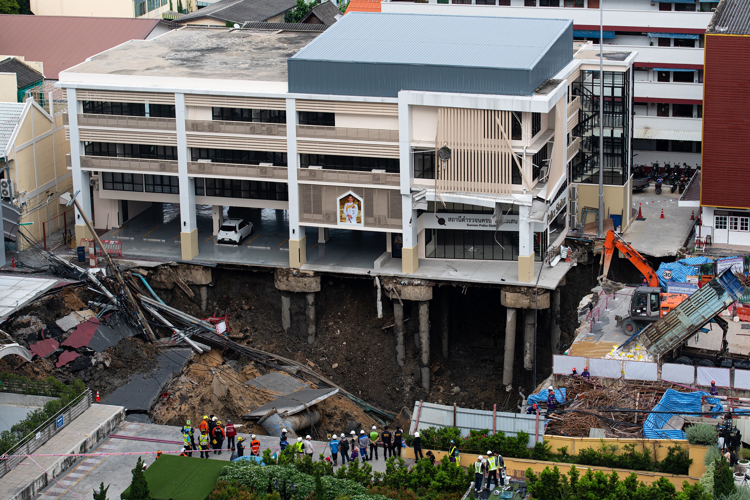 Rescue workers inspect a site of sinkhole next to the Samsen | Vezess | Vezess