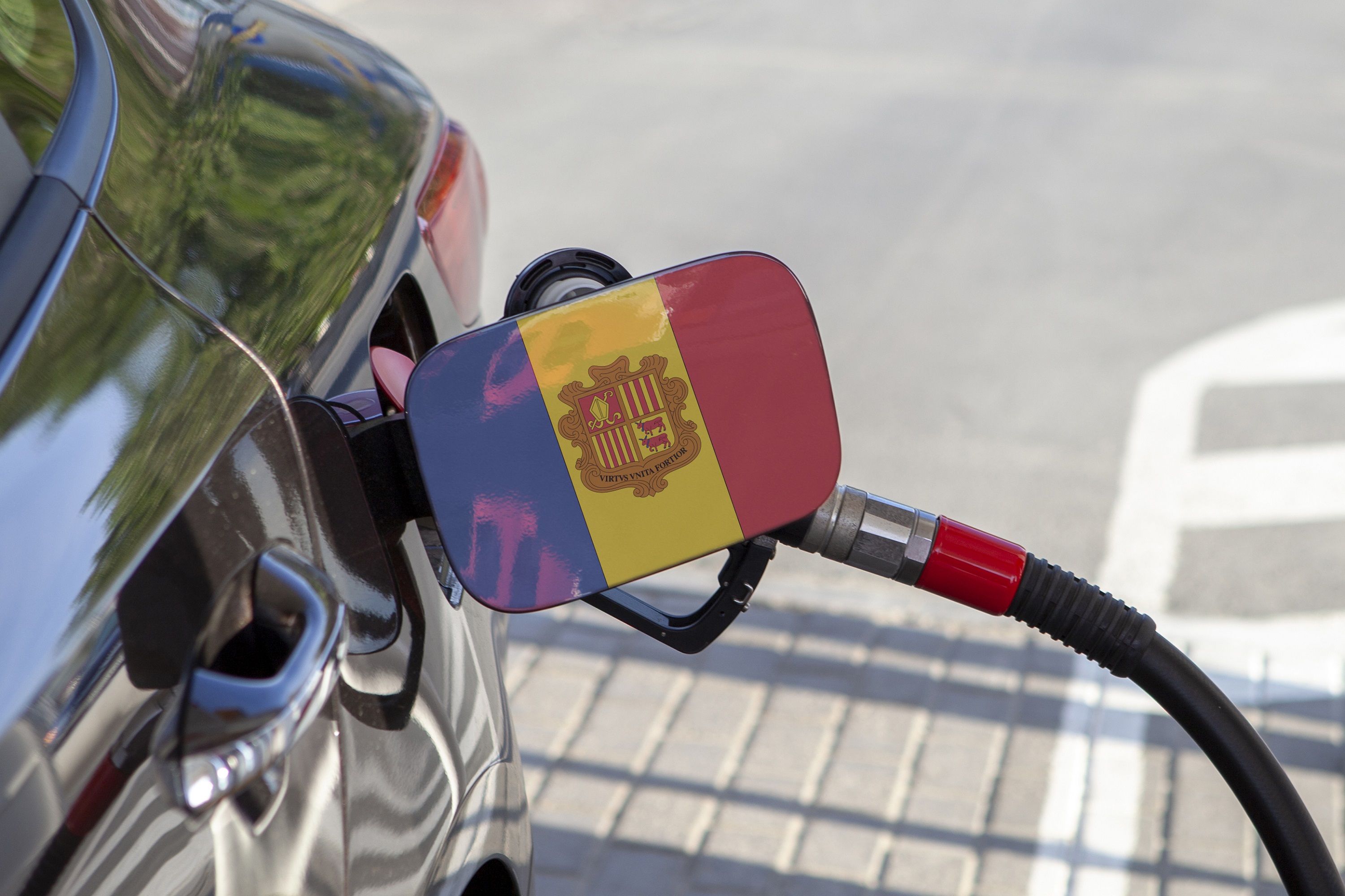 Flag of Andorra on the cars fuel tank filler flap Fueling car with petrol pump at a gas station Petrol station Gasoline and oil products Close up | Vezess | Vezess