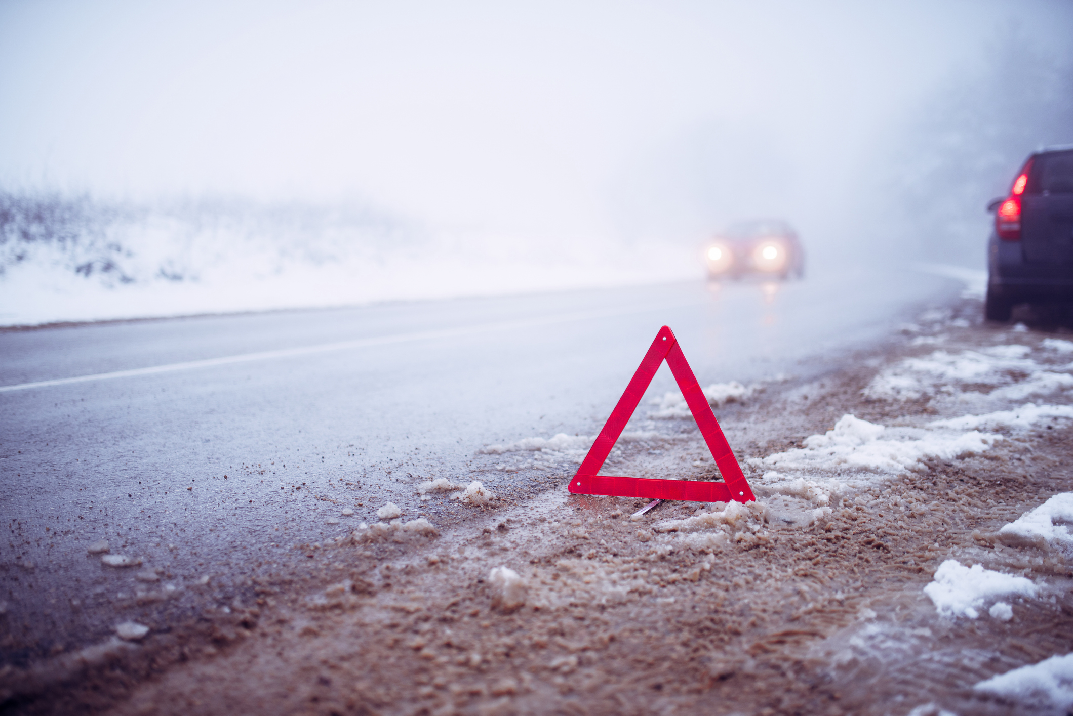 warning triangle placed on the roadway in winter conditions | Vezess | Vezess