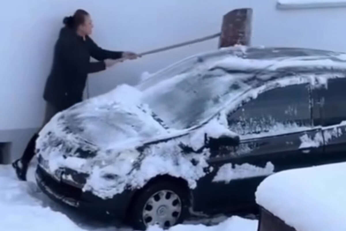 Csöndben sírt az autó, ahogy egy magyar hölgy takarította róla a havat