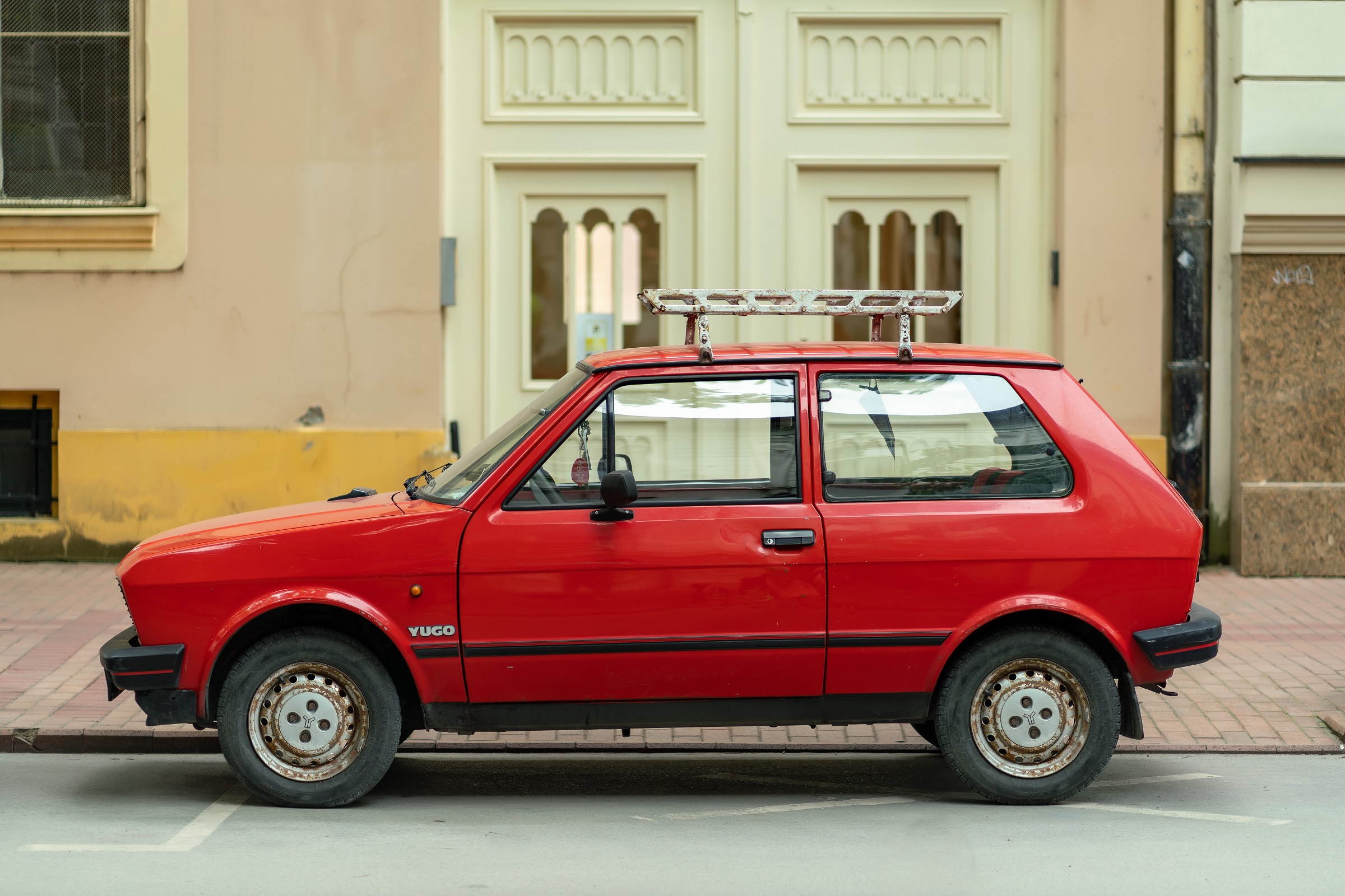 Side view of YUGO Koral Zastava Koral Yugo 45 55 in red color is parked | Vezess